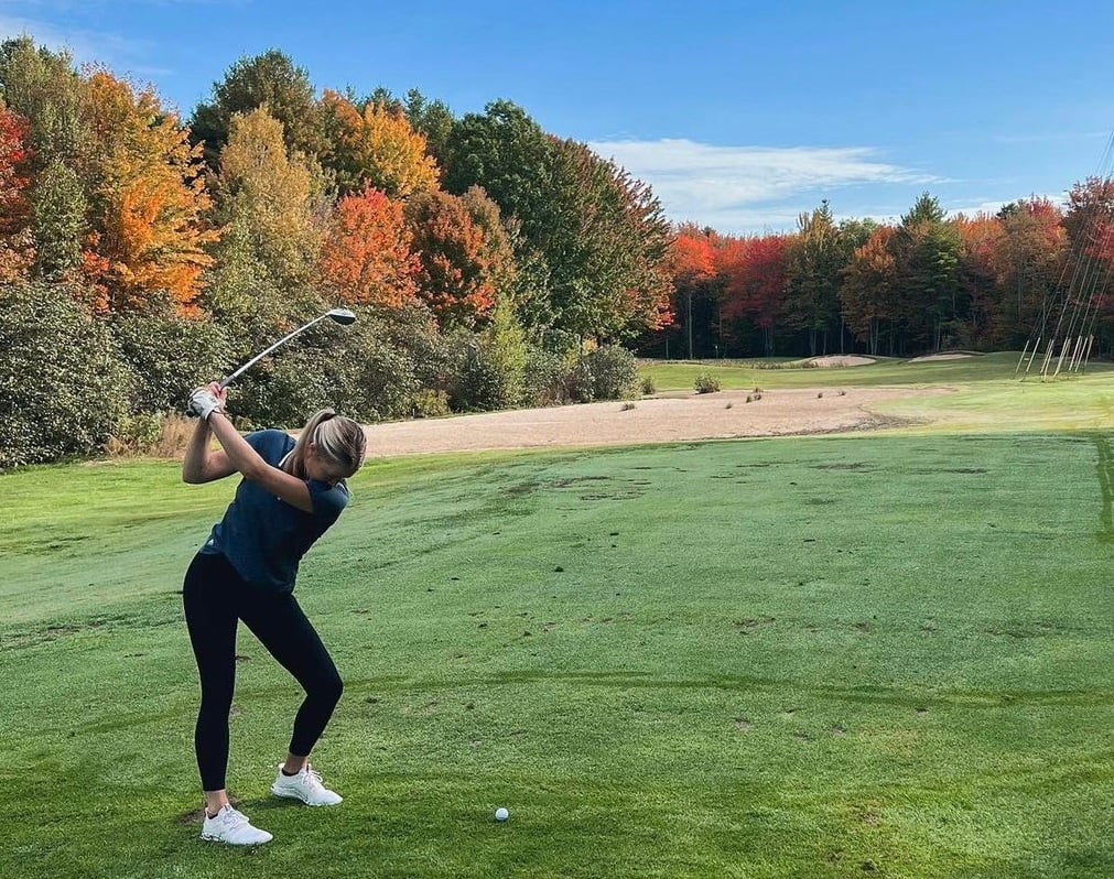 Dr. Robyn playing golf on a blue sky day in Maine.